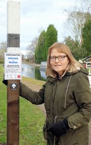 A person standing next to a sign
